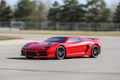 Sleek red remote control racing car on asphalt with dynamic low angle shot
